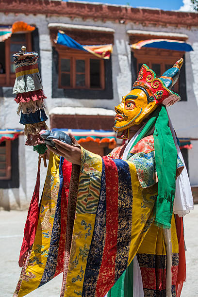 Buddhist monk is performing a sacred dance in Ladakh. Phyang, India - July 14, 2015: Buddhist monk is performing a sacred dance in the courtyard of Phyang Monastery, Ladakh. He is dressed in a traditional costume and is wearing  an old mask.  phyang monastery stock pictures, royalty-free photos & images