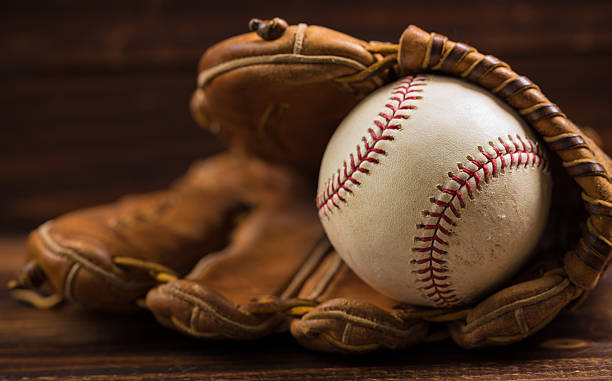 cuir des gants de base-ball et du ball sur du bois banc de musculation - baseball glove baseball baseballs old fashioned photos et images de collection
