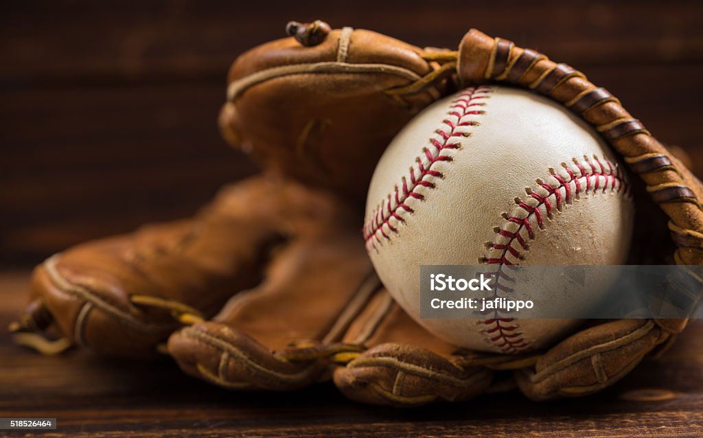 Leather baseball glove and ball on a wooden bench Brown leather baseball glove on a wooden bench Baseball - Ball Stock Photo