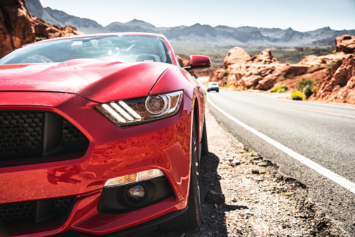 Overton, Nevada, USA - March 26, 2016: Front view of a red Ford Mustang GT parked along the road of the Valley of Fire Highway in the Valley of Fire park. Ford Mustang is a sport muscle car made in US by Ford.