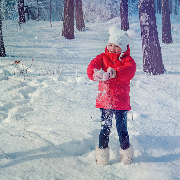istock Small girl playing with snow 518527478