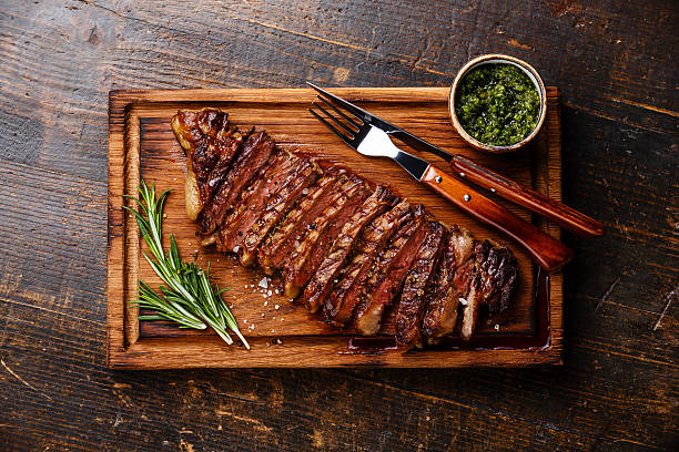 fatias sagital bife grelhado com molho chimichurri - molho verde imagens e fotografias de stock