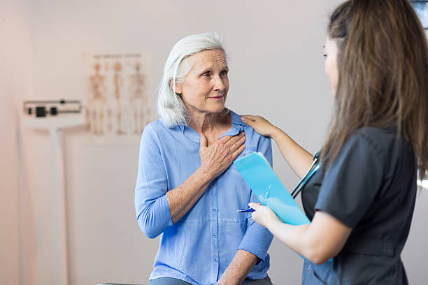 Senior Woman's Doctor's Office Visit For Chest Pain stock photo