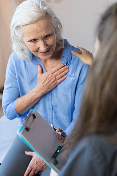 starszy kobiety w gabinecie lekarza podczas wizyty o ból w klatce piersiowej - nurse illness doctor heart disease zdjęcia i obrazy z banku zdjęć