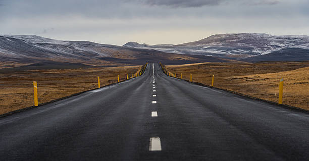 istock Road perspective with yellow field hill and mountain range background 518533162