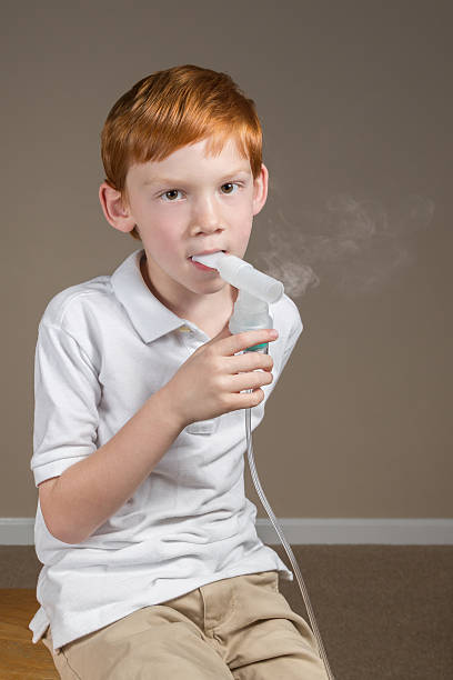 istock Young boy with asthma completing a breathing treatment 518533664