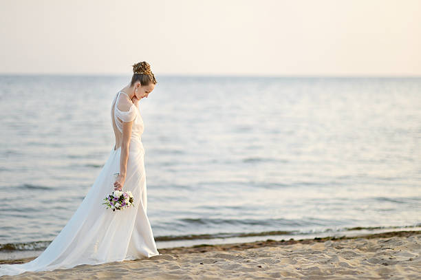 istock Bride walking along sea coast on sunset 518547153