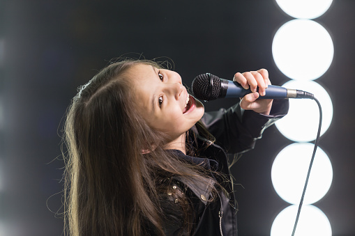 Young rockstar girl singing on stage
