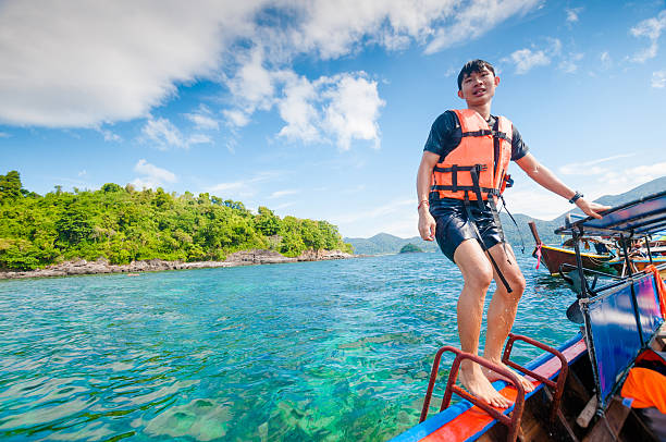 istock Man jumping off the boat into the ocean 518550028