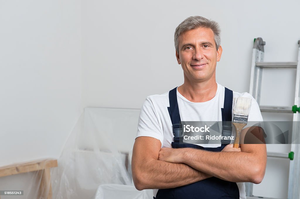 Portrait Of Happy Painter Portrait Of Smiling Painter With Arm Crossed Holding Paintbrush At Home House Painter Stock Photo