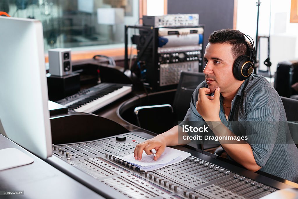 Working at mixing panel Hispanic sound engineer working at mixing panel in the recording studio Noise Stock Photo