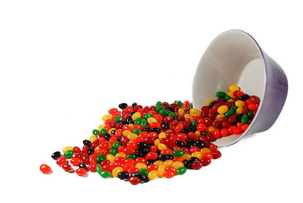 istock Brightly colored assorted jellybeans spilling from bowl 518553122