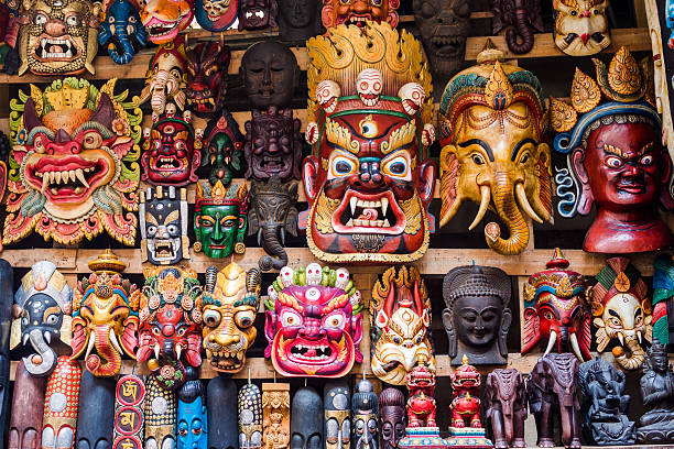 Colorful Masks at Street Stall in Kathmandu, Nepal Colourful wooden masks and handicrafts on sale at street stall in the Thamel District of Kathmandu, Nepal. ritual mask stock pictures, royalty-free photos & images