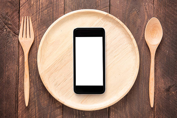 istock Eating smartphone on set of fork,spoon and dish wood 518561504