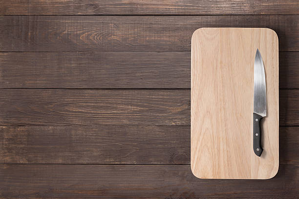 istock Knife and cutting board on the wooden background 518562430