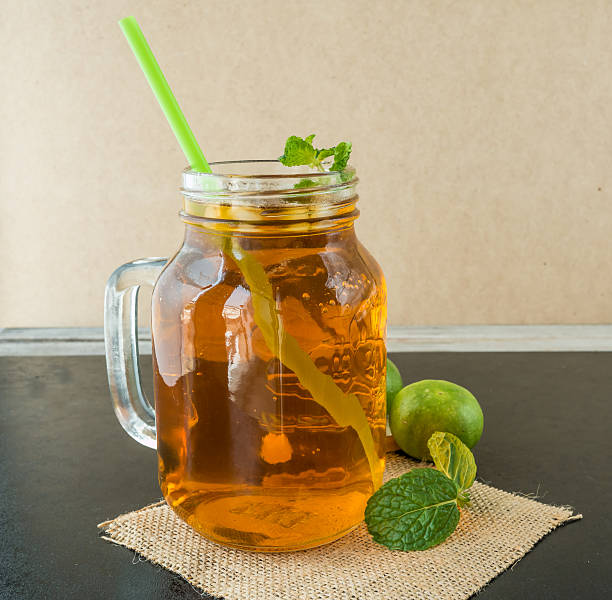istock Lemon ice tea on black wooden table, green mint, 518563644