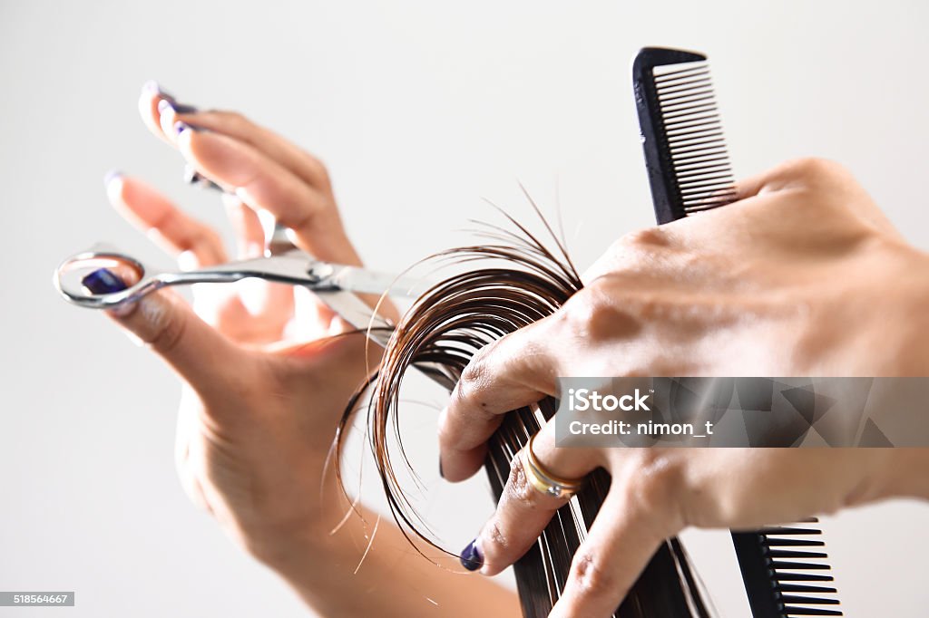 Hand with a comb cutting hair of woman Close up of beautician's hand with a comb cutting hair of woman Hairdresser Stock Photo
