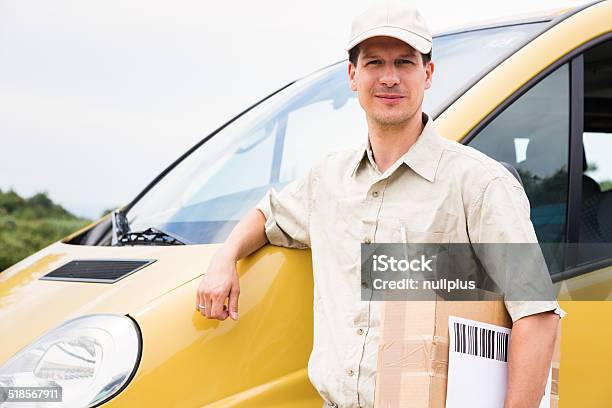 Messenger With Parcel Standing Next To His Delivery Van Stock Photo - Download Image Now