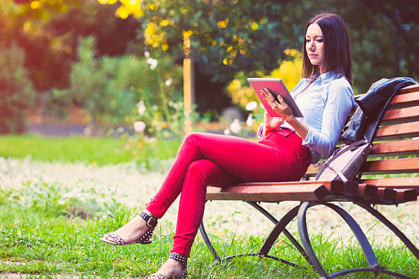 istock Woman using digital tablet in the park 518568777
