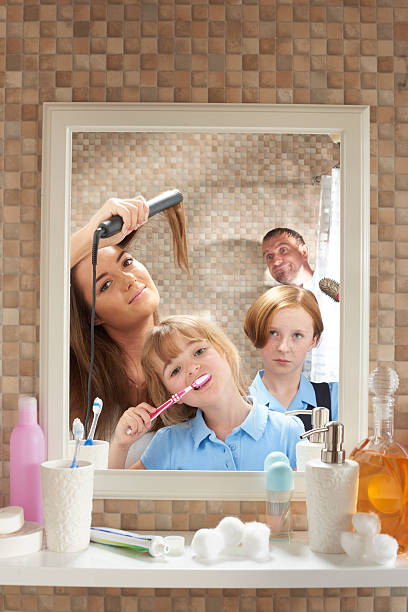 Bathroom morning privacy Three daughters of mixed ages fight for mirror space at the start of the day , much to there annoyance of father who is trying to have a shower in peace . He looks from the shower curtain annoyed at the lack of privacy . urgency mother working father stock pictures, royalty-free photos & images