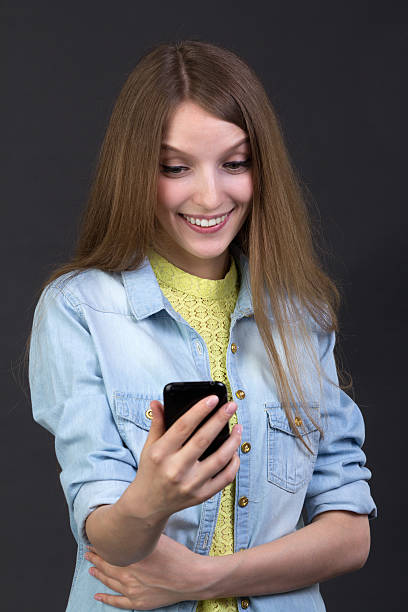 istock Young beautiful girl reads a text message on a cell phone 518587564