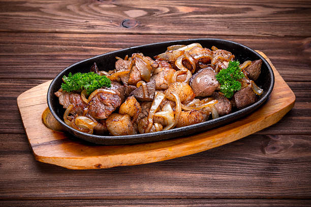 istock Frying pan with roasted meat and onion 518588822