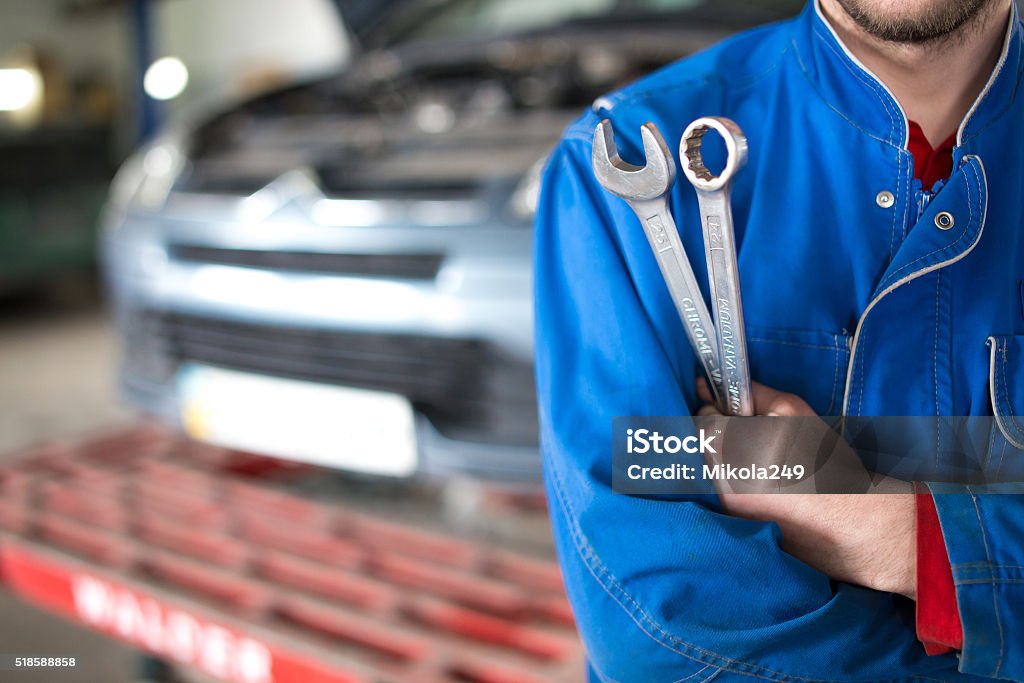 Hand of car mechanic with wrench. Auto repair garage. Car Stock Photo