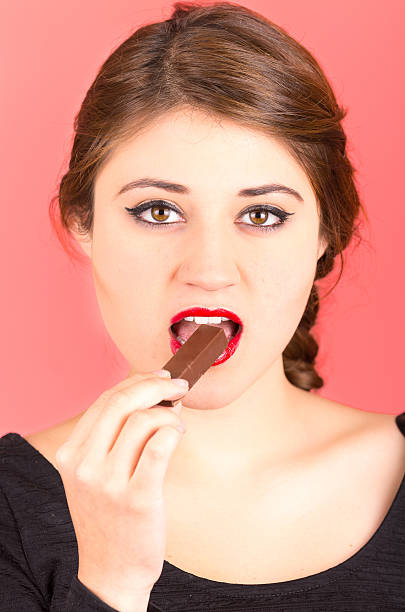 istock pretty young girl eating chocolate 518588939