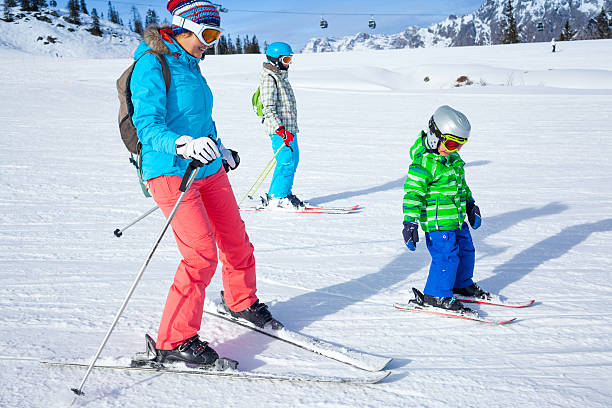 istock Two kids with mother enjoying winter vacations. 518589083