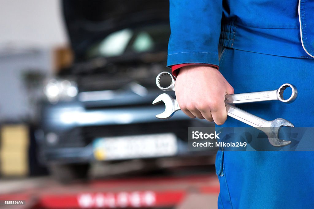 Mano de coche mecánico con llave. Automático garaje de reparación. - Foto de stock de Coche libre de derechos