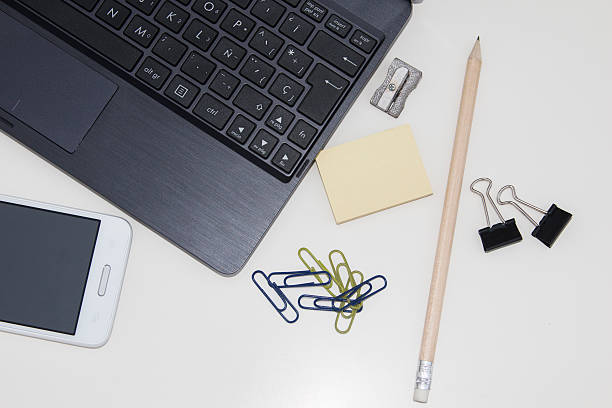 istock Workspace with laptop, mobile, clips, pencil, post it over white 518589787