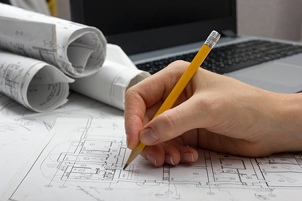 Architect working on blueprint. Architects workplace - architectural project, blueprints Architect working on blueprint. Architects workplace - architectural project, blueprints, ruler, calculator, laptop and divider compass. Construction concept. Engineering tools. autocad house plans stock pictures, royalty-free photos & images