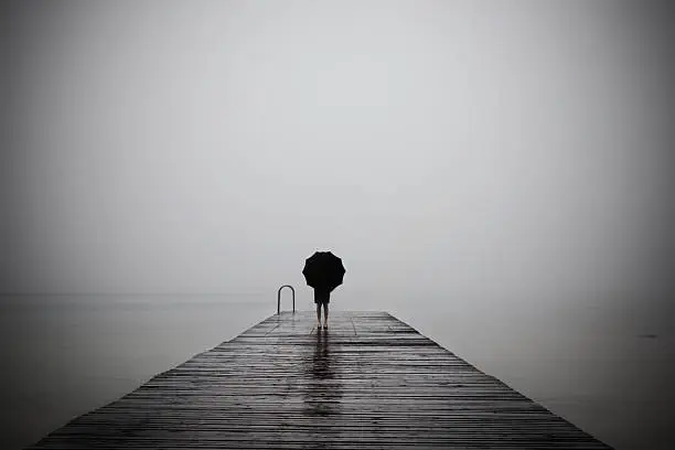 Photo of elegant woman dressed in black hiding with umbrella