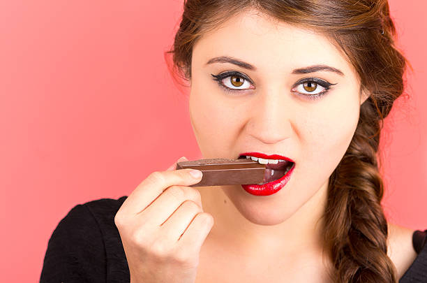 istock pretty young girl eating chocolate 518593113