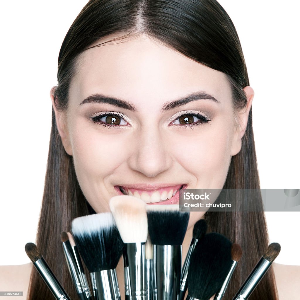 Beautiful girl with makeup brushes. Beautiful girl with makeup brushes on a white background. Adult Stock Photo