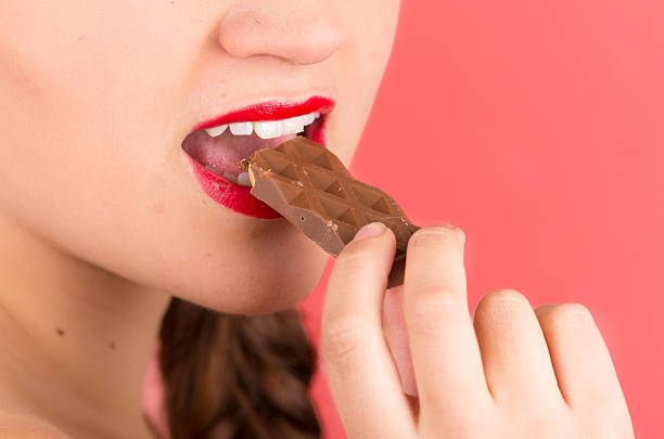 istock pretty young girl eating chocolate 518593479