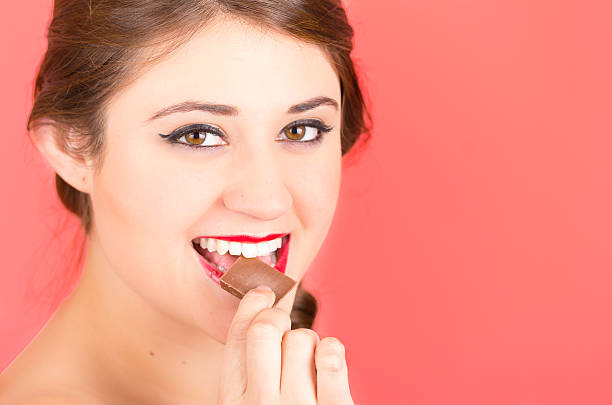 istock pretty young girl eating chocolate 518593847