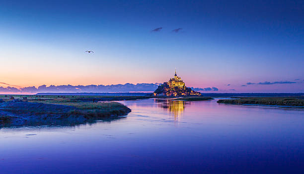 Mont Saint-Michel in twilight at dusk, Normandy, France Panoramic view of famous Le Mont Saint-Michel tidal island in beautiful twilight during blue hour at dusk, Normandy, northern France marazion photos stock pictures, royalty-free photos & images
