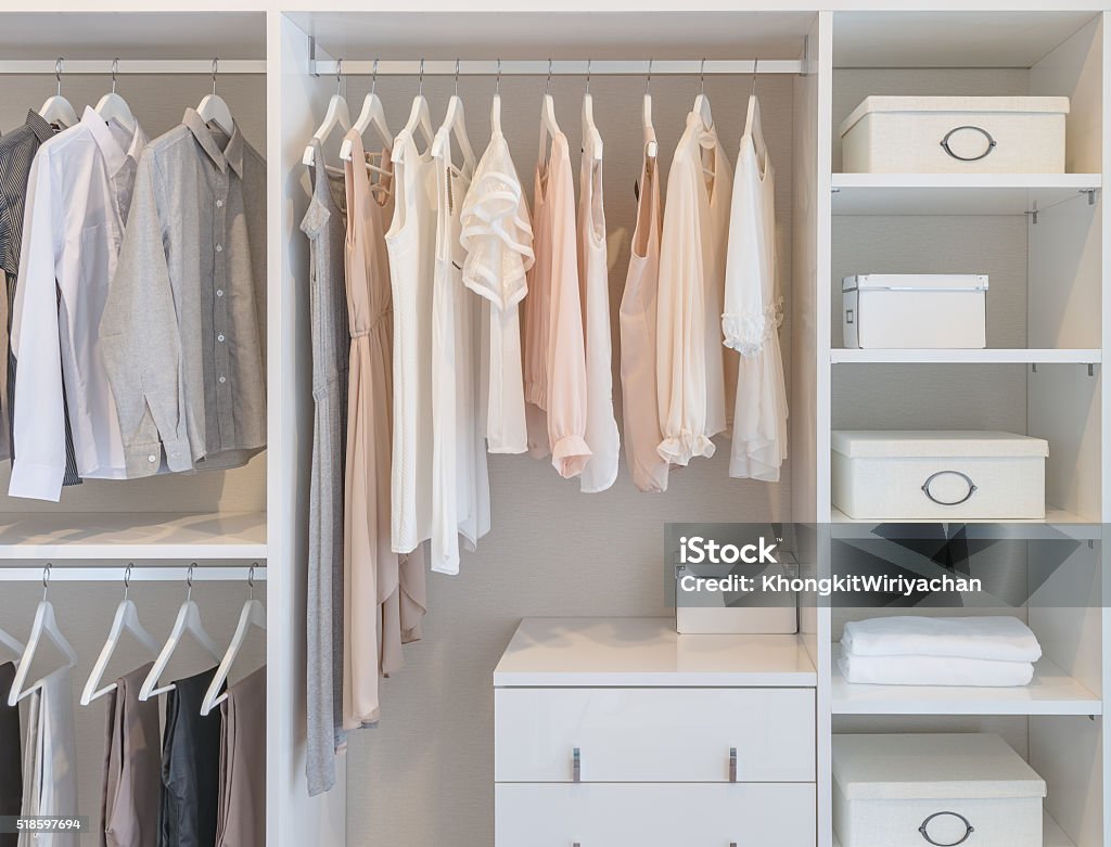 clothes hanging on rail in white wardrobe clothes hanging on rail in white wardrobe with boxes Closet Stock Photo