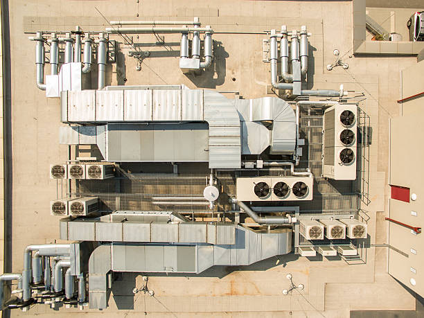 Air conditioning equipment atop a modern building Air conditioning equipment atop a modern building - aerial drone view of the roof with all the necessary installations refrigeration business air conditioner factory stock pictures, royalty-free photos & images