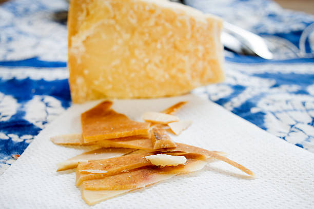 chunks and rind of parmigiano cheese with near a big piece of heart
