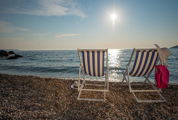 istock Striped deck chairs on shore at Vis island 518617982