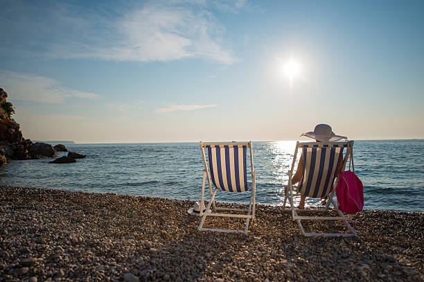 istock Woman relaxing on deck chair at beach 518618340