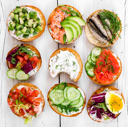 Small sandwiches on wooden rustic background, top view.