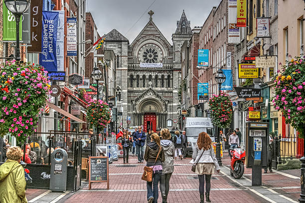 Grafton Street Dublin Ireland Shoppers Famous shopping area in Dublin, Ireland.  Grafton Street showing shoppers, shops and church. dublin republic of ireland photos stock pictures, royalty-free photos & images