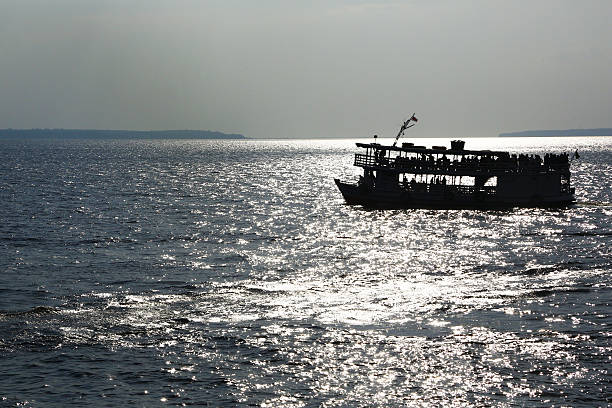 The blinding light of tropical sun behind a ferry sailing on Rio Negro close to Manaus, Brazil
