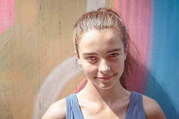 istock toned image, smiling girl in front of a graffiti 518624647