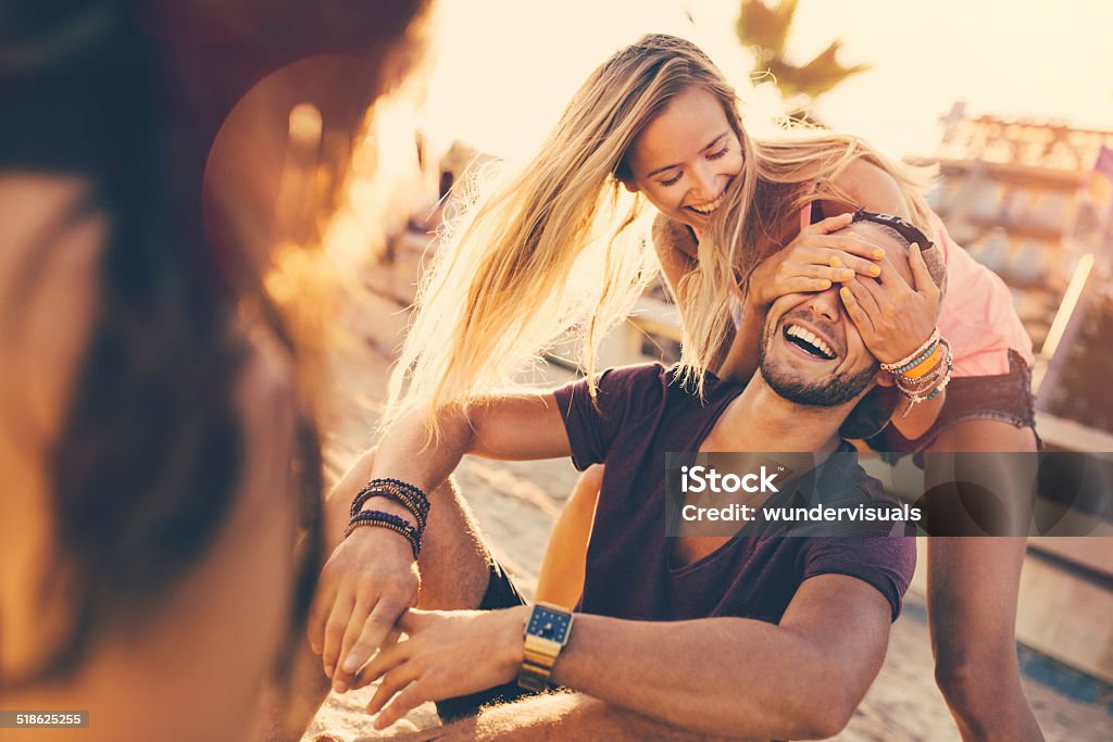 Girl Surprises Guy Girl surprises guy at on the beach Hands Covering Eyes Stock Photo