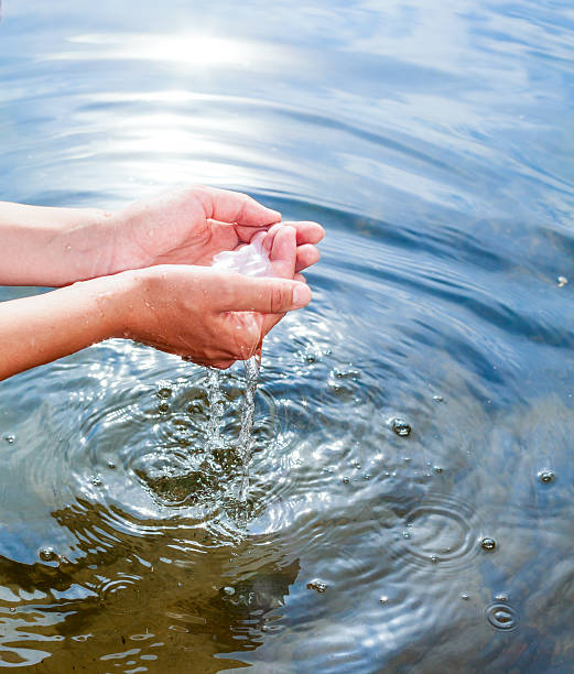 Holding water in cupped hands stock photo