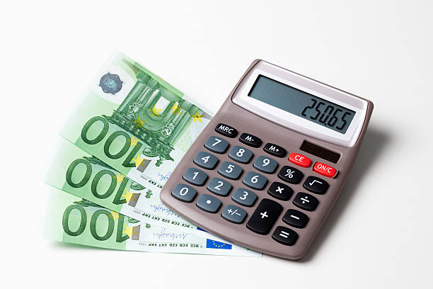 istock Calculator with fanned Euro notes and coins on white background 518626015